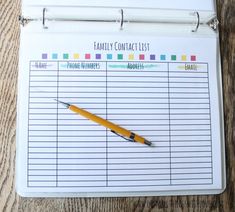 a yellow pen sitting on top of a clipboard with a family contact list attached to it