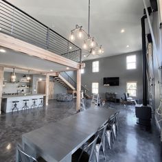 a large open floor plan living room and dining area with stairs leading up to the second floor