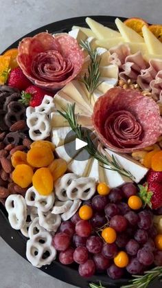 a platter filled with cheese, fruit and meats