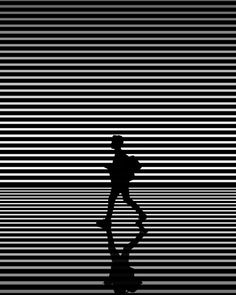 the silhouette of a man walking across a black and white background