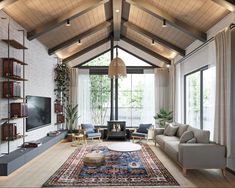 a living room filled with furniture and a large rug on top of a hard wood floor