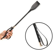 a hand holding a black and gold spatula with an o - ring on it