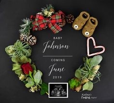 a wreath with baby feet and christmas decorations on it, surrounded by greenery and pine cones