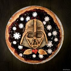 a star wars themed pie on a wooden table with white snowflakes around it