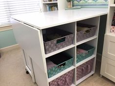 a white desk with baskets on it and some bookshelves in front of it