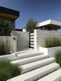 a modern house with concrete steps leading up to the front door