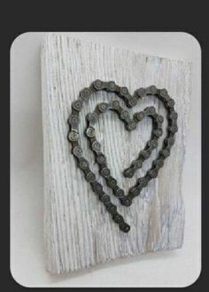 a heart made out of metal beads on a white wooden plaque with a black frame