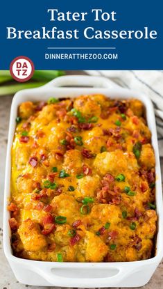 tater tot breakfast casserole in a white dish with green onions and bacon