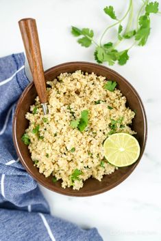 a brown bowl filled with rice and cilantro on top of a blue towel