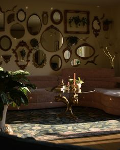 a living room filled with furniture and lots of mirrors on the wall above it's coffee table