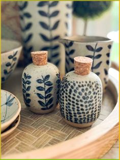 three ceramic vases sitting on top of a wooden tray