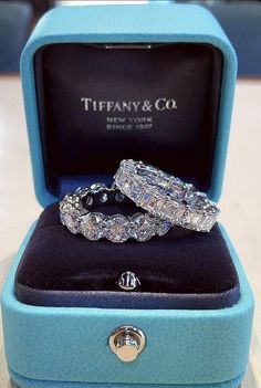 two wedding rings sitting in a blue box