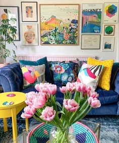 a living room filled with lots of furniture and flowers on top of a coffee table