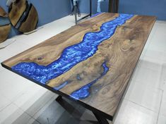 a wooden table with blue paint on it in a room next to other furniture and accessories