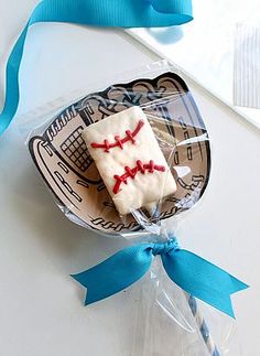 a piece of cake in a plastic wrapper with blue ribbon around it on a table