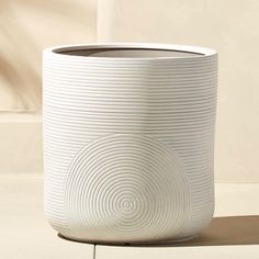 a white vase sitting on top of a table