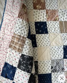 an old patchwork quilt is laying on top of a bed sheet that has been turned into a blanket