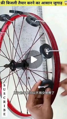 a person holding a wheel on top of a red rim with black spokes in front of a white background