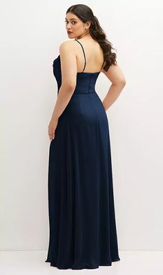 a woman in a dark blue dress is looking back