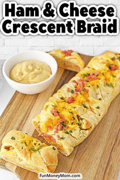 ham and cheese crescent bread is on a cutting board next to a bowl of dip