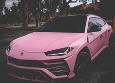 a pink sports car parked in a parking lot