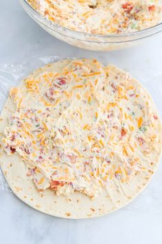 two tortillas covered in cheese on top of a white counter next to each other