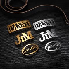 Assorted gold and silver belt buckles with names 'DANNY,' 'JIM,' and 'Janette' on a black textured background with a brown belt. Engraved Necklace Mothers, Hip Hop Accessories, Custom Belt Buckles, Lucky Charm Necklace, Leather Belt Buckle, Wedding Gifts For Groomsmen, Mothers Bracelet, Promise Rings For Couples, Custom Belt