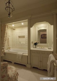 a bath room with a tub a sink and a mirror on the wall in it