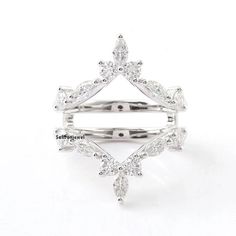 a white gold and diamond ring on a white background with clippings to the side