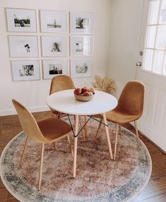 a white table and chairs in a room with pictures on the wall