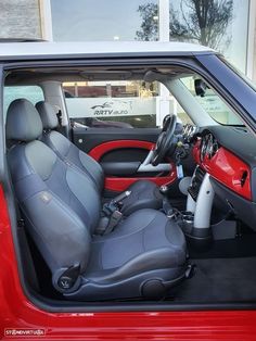 the interior of a red car with black leather seats