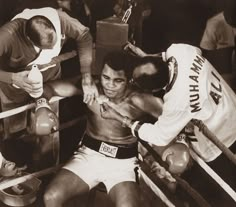 an old black and white photo of two men in the ring with their hands on each other's shoulders