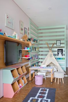 a child's playroom with a teepee tent on the wall and shelves