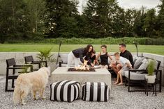 a family sitting around a fire pit with their dog