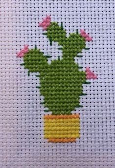 a cross stitch cactus with pink flowers in a yellow pot