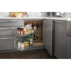 an open cabinet in a kitchen with spices and condiments on the bottom shelf