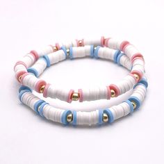 two bracelets with white, blue and red beads are shown on a white surface