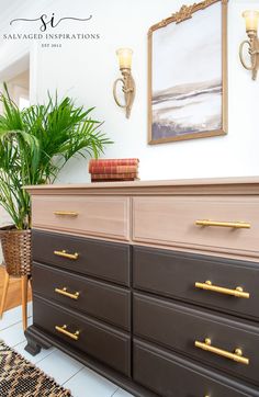 a dresser with gold handles and drawers in a living room next to a potted plant