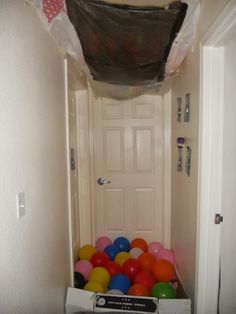 a bunch of balls are in a box on the floor next to a white door