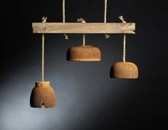 three breads hanging from ropes in front of a black wall with two wooden hooks