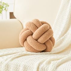 a knot pillow sitting on top of a white couch