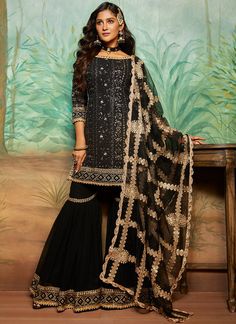 Black and Gold Thread Embroidered Gharara Suit Bollywood Style Black Palazzo Set With Sheer Dupatta, Black Anarkali Palazzo Set With Resham Embroidery, Unstitched Black Sharara With Resham Embroidery, Black Anarkali Palazzo Set In Georgette, Black Anarkali Palazzo Set With Sheer Dupatta, Black Resham Embroidery Unstitched Sharara, Black Sharara With Dabka Work For Eid, Black Sharara With Resham Embroidery In Chinon, Black Sharara With Straight Kurta And Dupatta