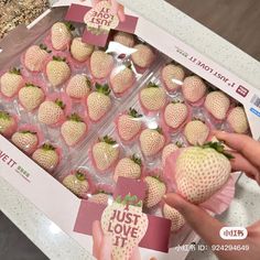 someone is holding up some strawberries in a box with the words just love it