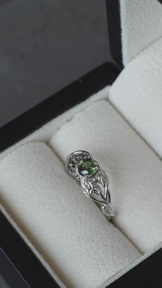 an engagement ring with a green stone in it