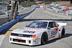 a white car driving down a race track