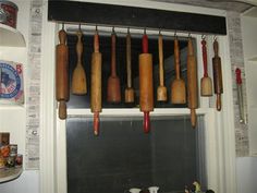 several wooden utensils hanging from hooks on a window sill in a kitchen