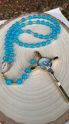 "Rosary to the Holy Spirit made with 8mm Glass Blue beads, 6mm gold spacers were used, the centerpiece is Our Lady of Guadalupe of 1\" or 2 cm. The wire that was used 7 strand Satin Copper, the crucifix of the rosary is of the Holy Spirit On the front and on the back is the sacred heart of Jesus, it measures 3.5\" or 9 cm. The total measurement of the rosary is 20\" or 51cm. Beautiful instrument of prayer or to give as a gift." Spiritual Beaded Rosary For Blessing, Spiritual Rosary With 8mm Beads For Blessing, Spiritual Rosary With Colorful Beads As Gift, Spiritual Colorful Beads Rosary As Gift, Spiritual Turquoise Rosary With Round Beads, Turquoise Rosary With Round Beads, Wisdom And Discernment, Jesus Sacred Heart, Bordados Tambour