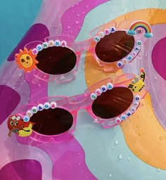 three pairs of sunglasses sitting on top of an inflatable object with water droplets