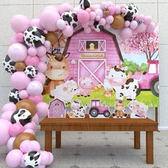 a table topped with balloons and farm animals