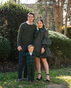 a man and woman standing next to a boy